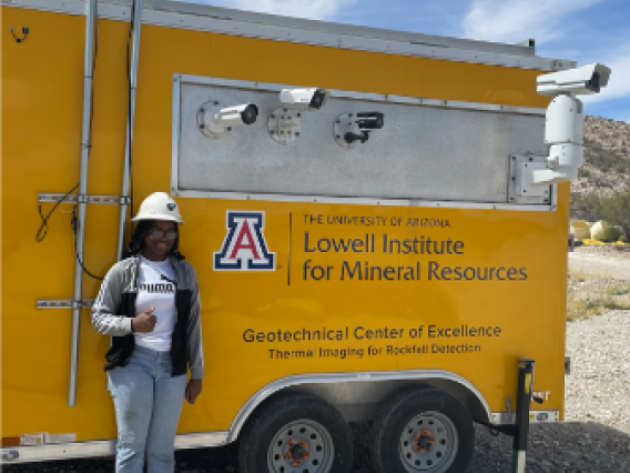 standing in front of a lowell institute truck