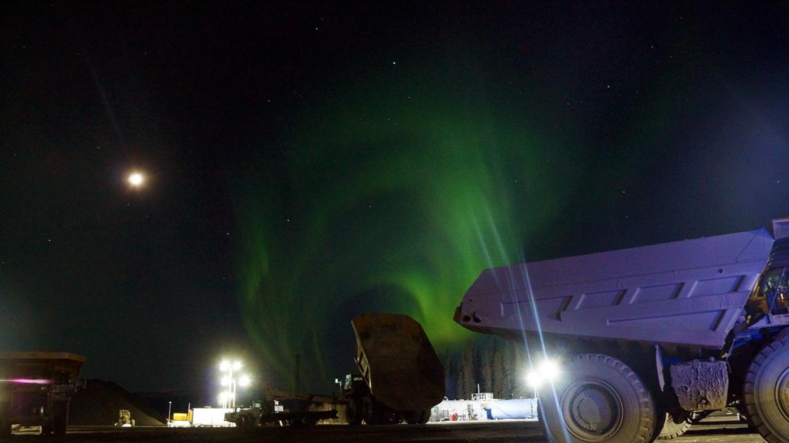 CAT 785 trucks parked at the fuel yard with aurora borealis, Usibelli Coal Mine, Healy, Alaska