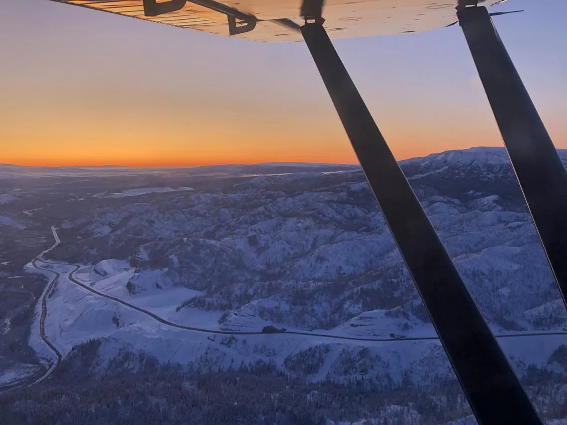 Description: This photo was taken in October 2019 during the onset of winter. I took this photo at sunset looking west, with the foothills of the Alaska Range aglow with the fall sunset. The haul roads in the photo lead to the Gold Run Pass and Jumbo Dome Mine permit areas, which are 13 and 15 miles from the crusher, respectively.